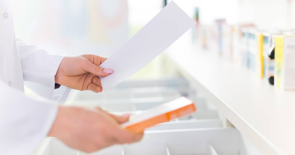 Pharmacist looking at prescription and counting pills